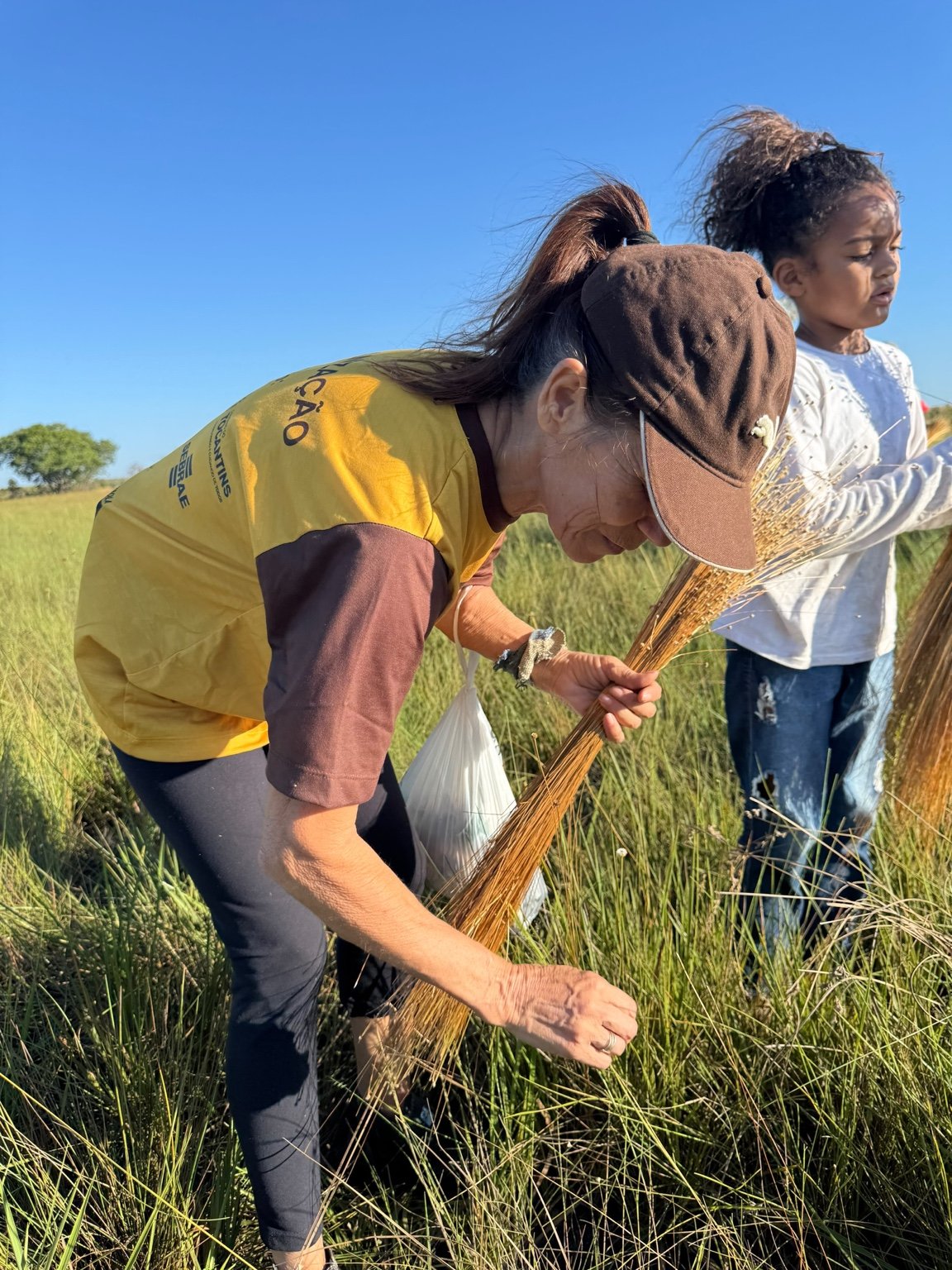 Woman and girl harvesting capim dourado in Jalapão, Brazil